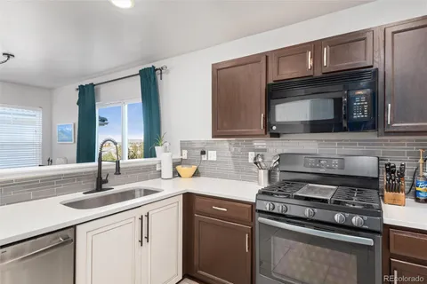 a kitchen with stainless steel appliances granite countertop a stove top oven a sink and dishwasher
