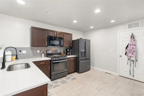 a kitchen with stainless steel appliances granite countertop a refrigerator and a sink