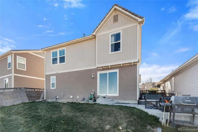 a backyard of a house with table and chairs