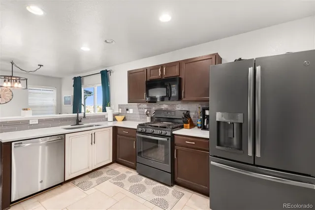 a kitchen with stainless steel appliances granite countertop a stove top oven a sink and dishwasher
