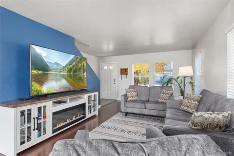 a living room with furniture a flat screen tv and a fireplace