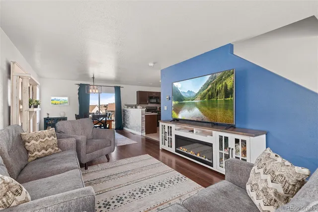 a living room with furniture a flat screen tv and a fireplace