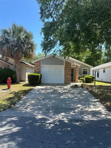 a view of a house with backyard and a tree