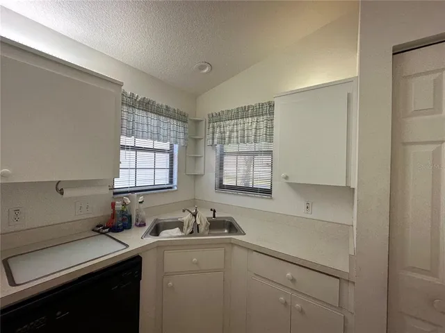 a kitchen with a sink cabinets and window