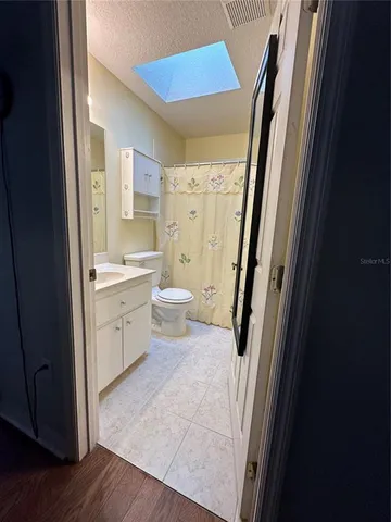 a bathroom with a sink a toilet a mirror and a shower