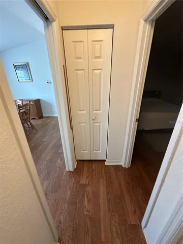 a view of a hallway with wooden floor and staircase