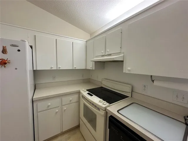 a view of a kitchen with white cabinets