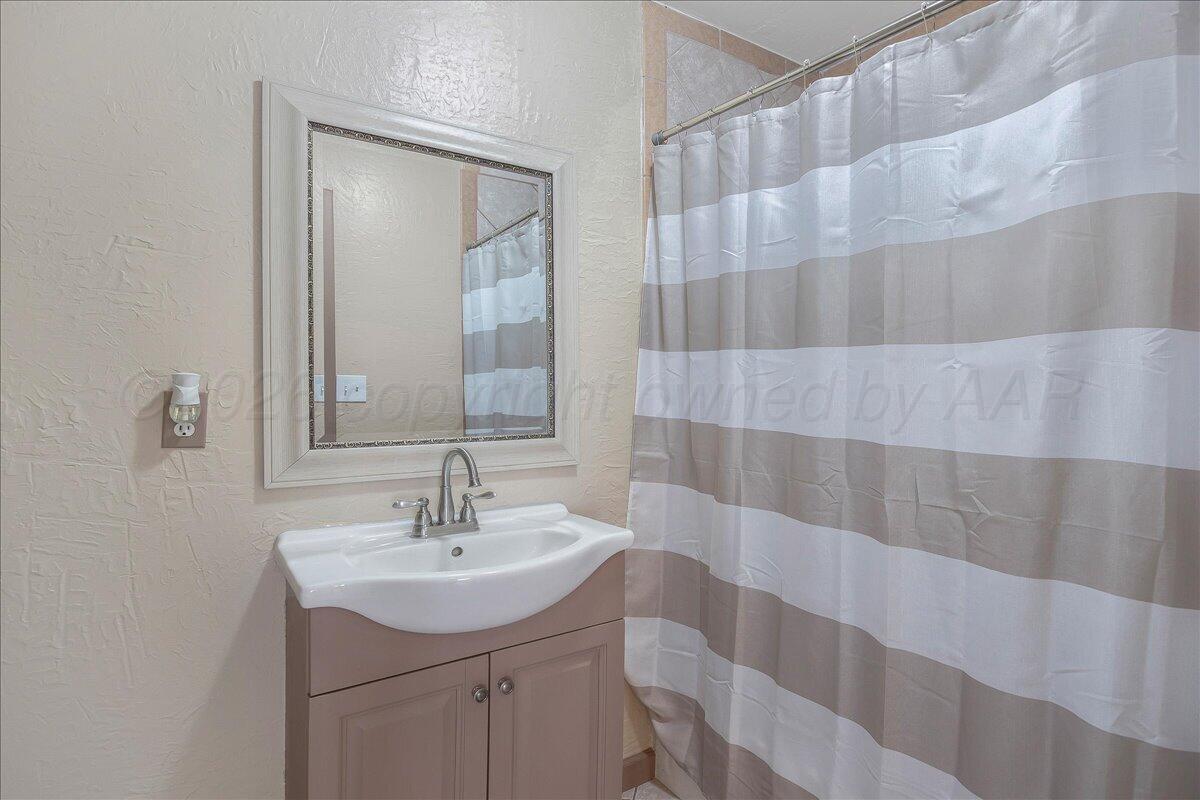 1504 Birch Street Amarillo, TX 79107 - Photo 13 of 19 a bathroom with a sink a mirror and shower