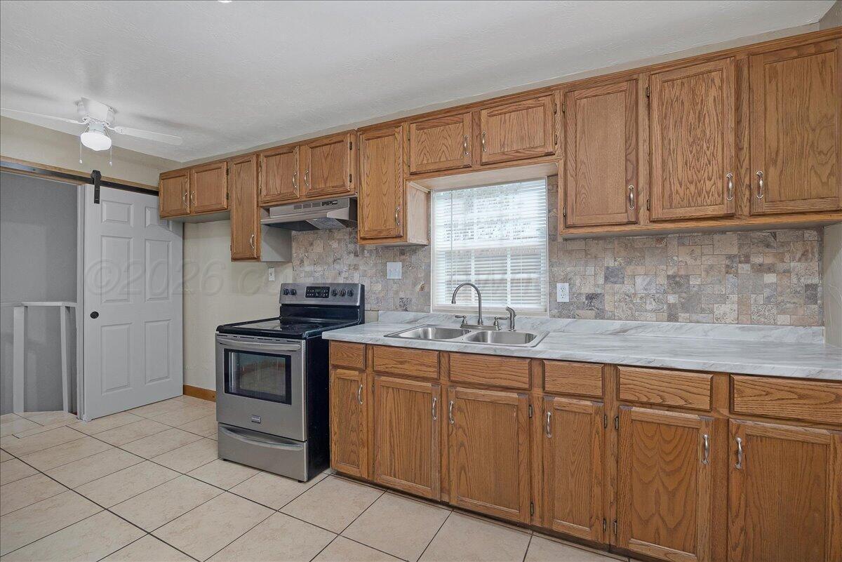 1504 Birch Street Amarillo, TX 79107 - Photo 7 of 19 a kitchen with stainless steel appliances granite countertop a sink and a stove