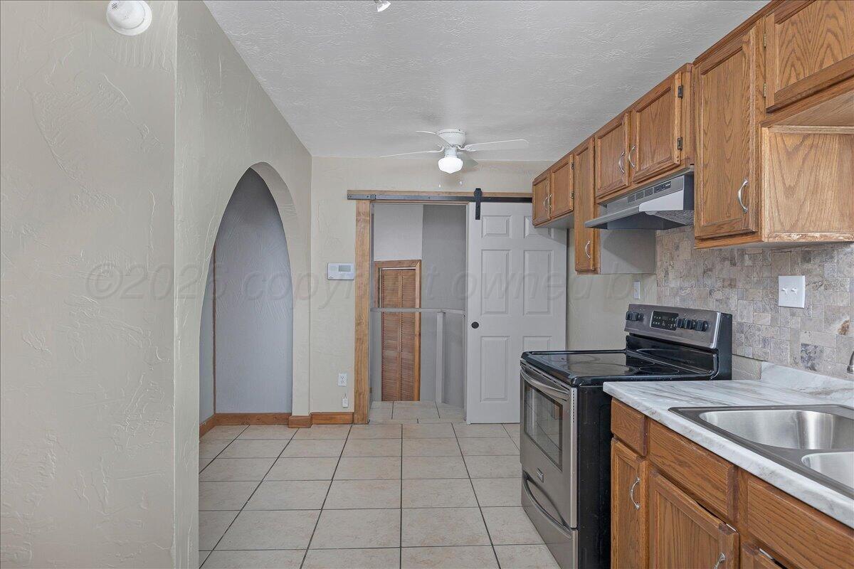 1504 Birch Street Amarillo, TX 79107 - Photo 9 of 19 a kitchen with a sink cabinets and a refrigerator