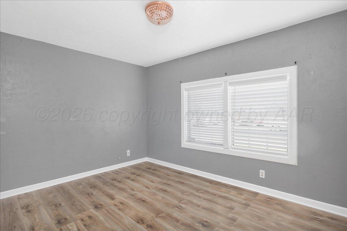 1504 Birch Street Amarillo, TX 79107 - Photo 10 of 19 a view of an empty room with wooden floor and a window