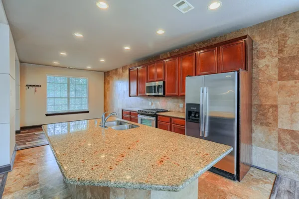 a kitchen with stainless steel appliances granite countertop a stove and a refrigerator