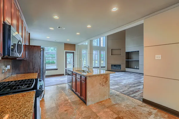 a view of a room with wooden floor a fireplace and window