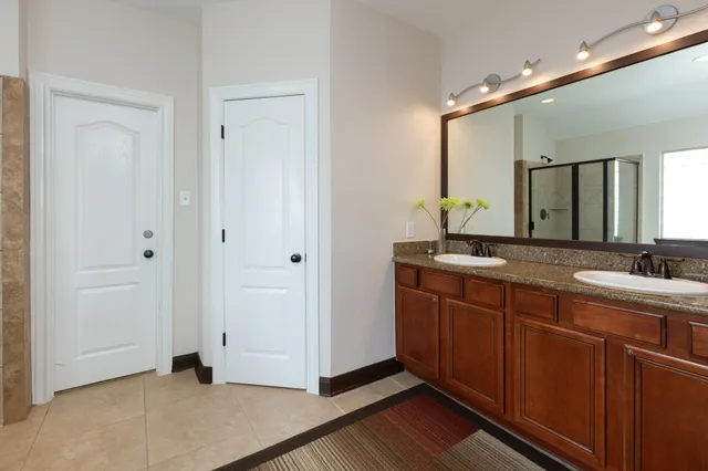a spacious bathroom with a double vanity sink and a mirror