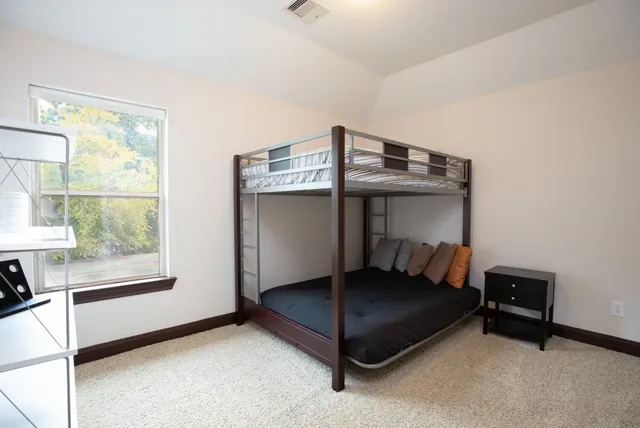 a living room with a bed and a window