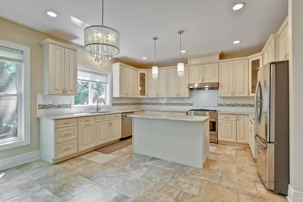 a kitchen with a refrigerator a sink cabinets and wooden floor