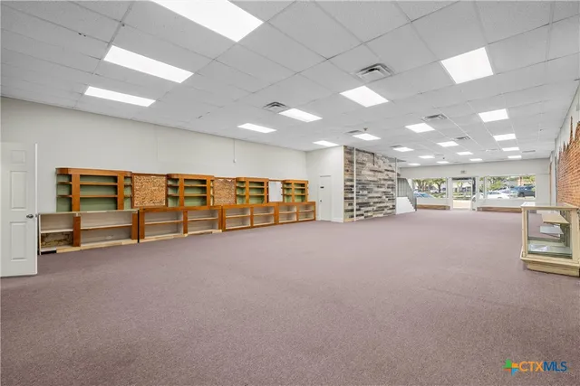 a view of an empty room with a window and couch