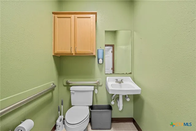 a bathroom with a toilet sink and mirror