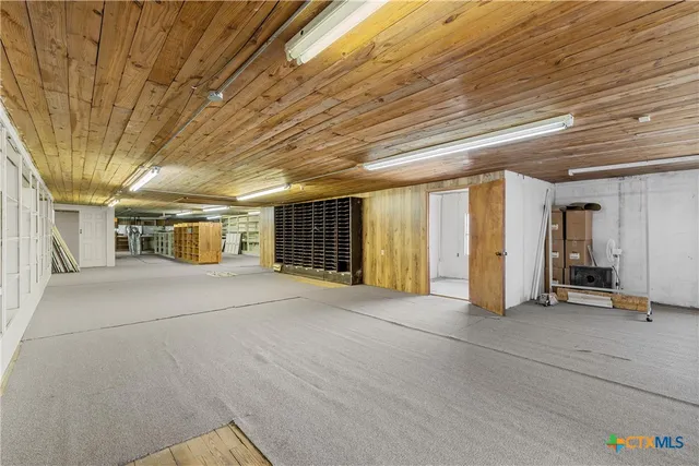 a view of empty room with wooden floor and windows