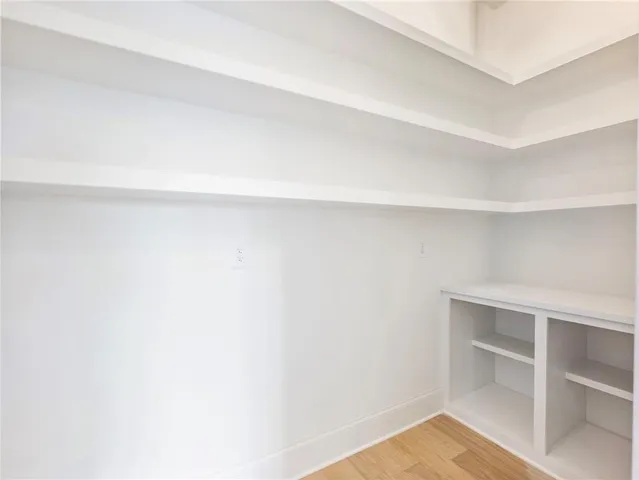 a view of an empty room with chandelier fan and window
