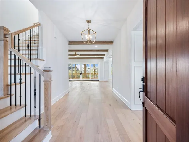 a view of an empty room with wooden floor fireplace and a window