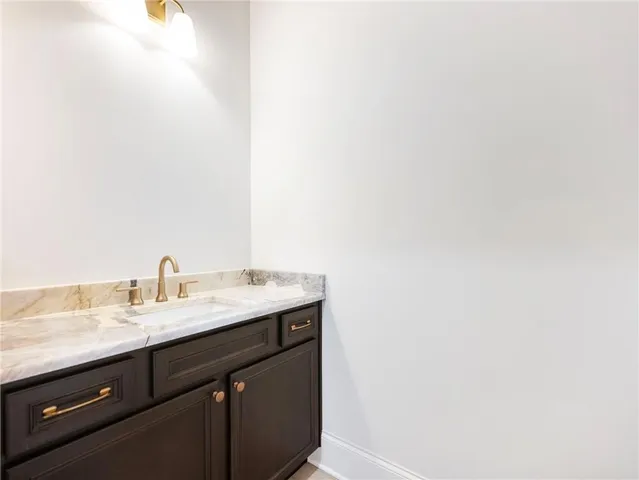 a view of a livingroom with a fireplace a ceiling fan and windows