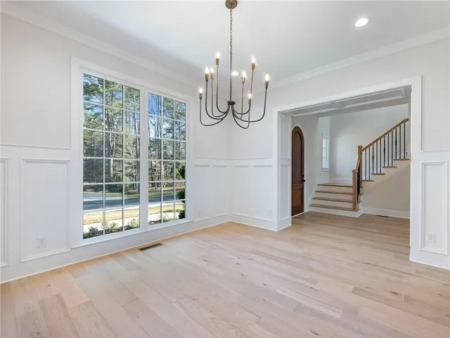 a view of a hallway with wooden floor and a kitchen