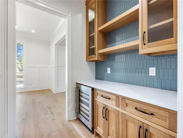 a large kitchen with stainless steel appliances a large counter top a sink a refrigerator and white cabinets