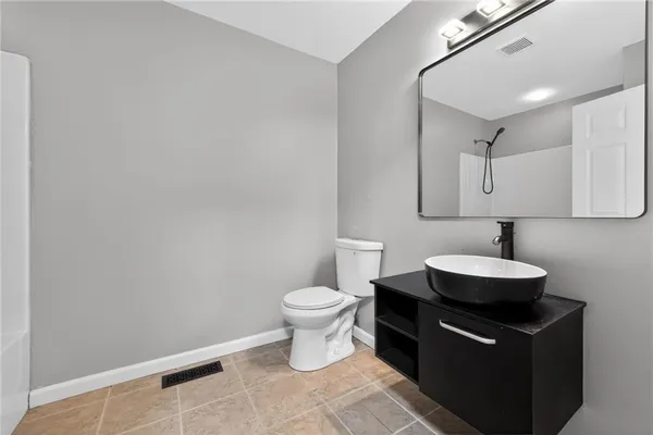 a bathroom with a sink toilet and a mirror