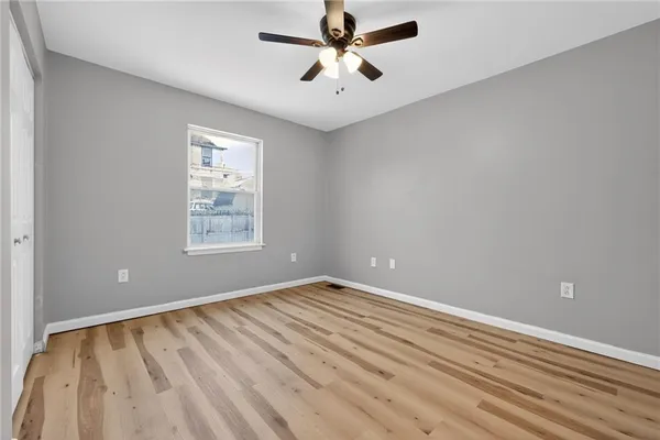 an empty room with windows and fan