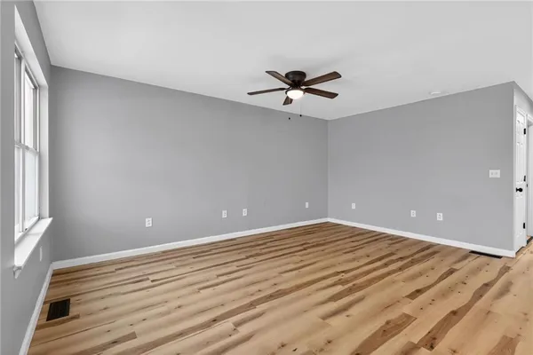 a view of room with wooden floor and ceiling fan