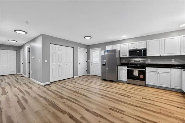 a view of a kitchen with wooden floor and electronic appliances
