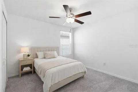 a bedroom with a bed and a ceiling fan
