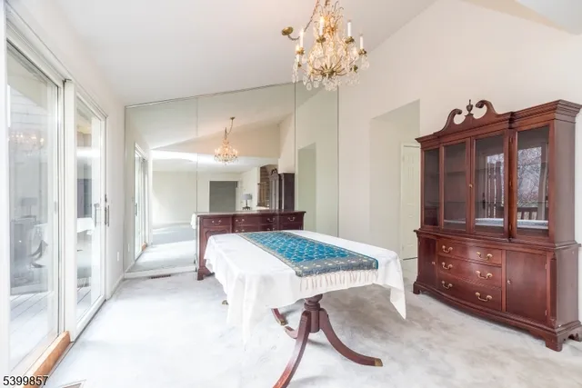 a view of spacious bedroom with furniture and chandelier