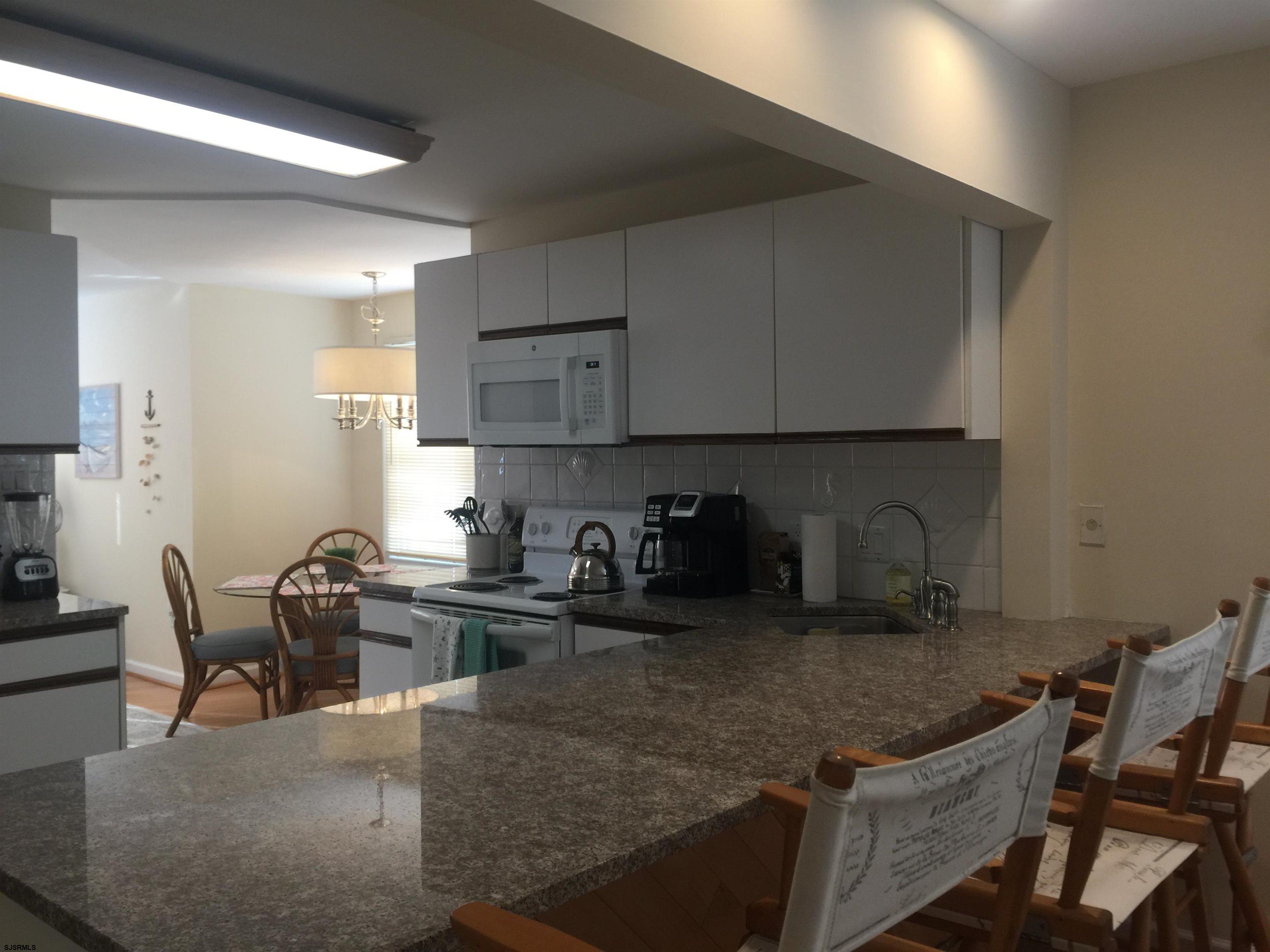 4013 West Brigantine Avenue, Unit 1 Brigantine, NJ 08203 - Photo 11 of 33 a kitchen with granite countertop a sink a stove and a microwave