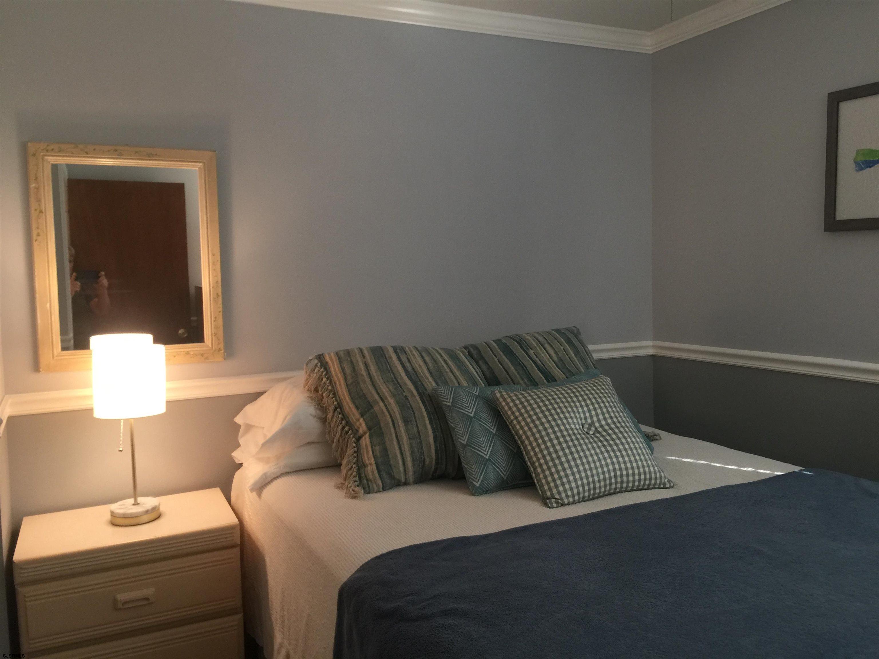 4013 West Brigantine Avenue, Unit 1 Brigantine, NJ 08203 - Photo 19 of 33 a bedroom with a bed and a lamp