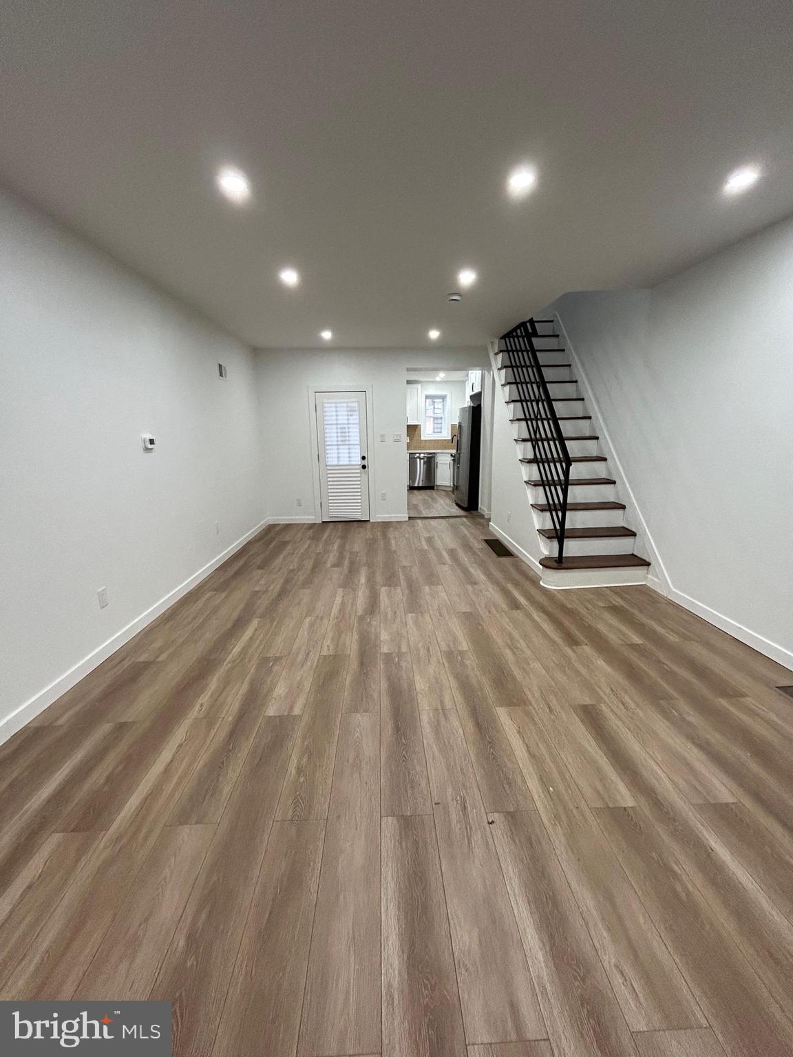 1163 Gerritt Street Philadelphia, PA 19147 - Photo 2 of 11 an empty room with wooden floor staircase and windows