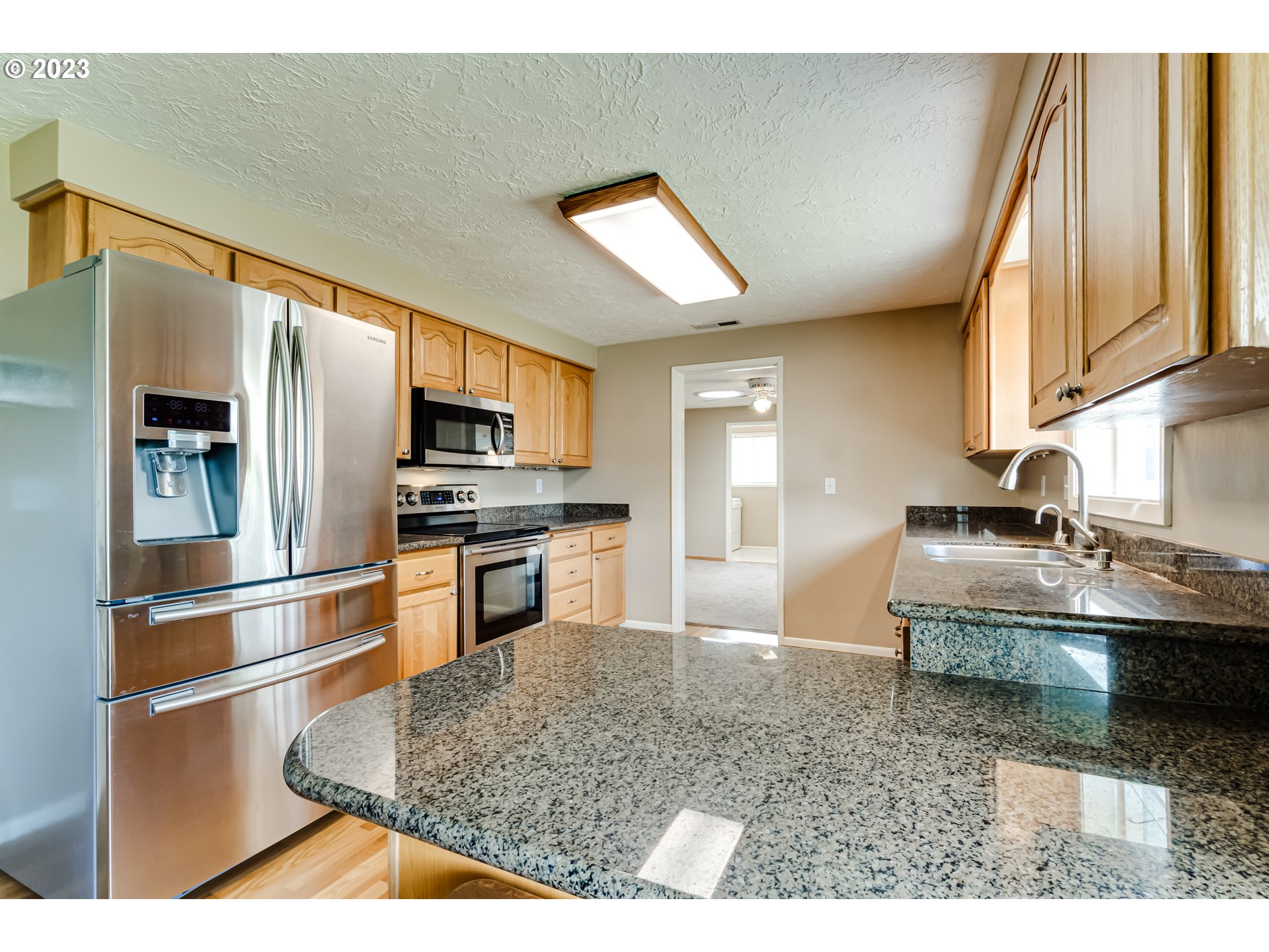 2407 17th Street Springfield, OR 97477 - Photo 17 of 40 a kitchen with stainless steel appliances granite countertop a sink stove and refrigerator