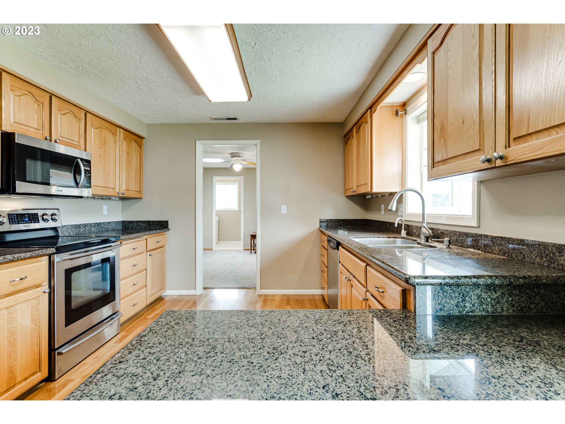 2407 17th Street Springfield, OR 97477 - Photo 18 of 40 a kitchen with stainless steel appliances granite countertop a stove a sink and a microwave