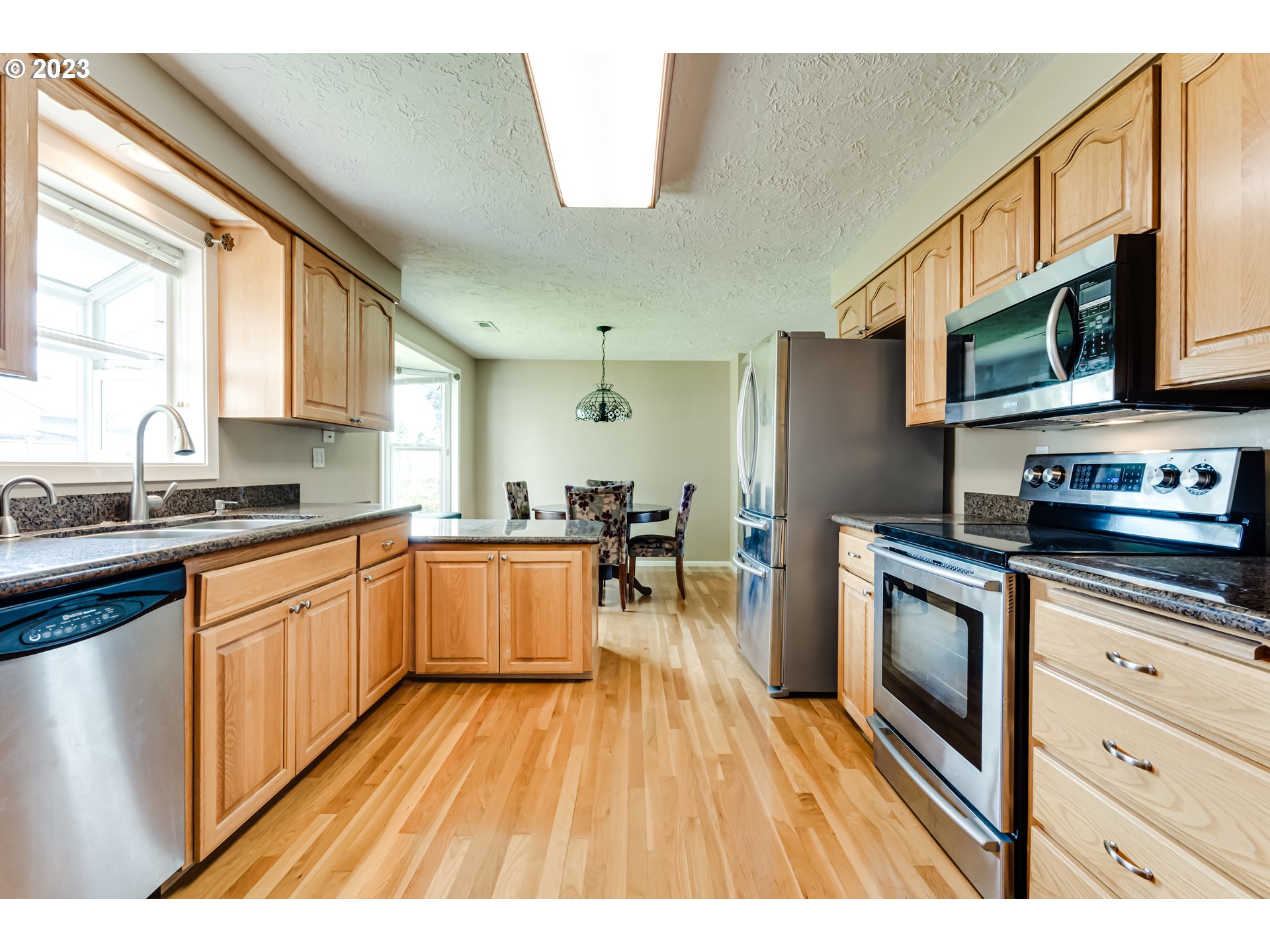 2407 17th Street Springfield, OR 97477 - Photo 19 of 40 a kitchen with stainless steel appliances wooden floors and view living room