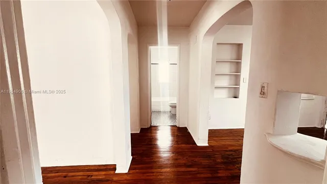 a view of a hallway with wooden floor and cabinet