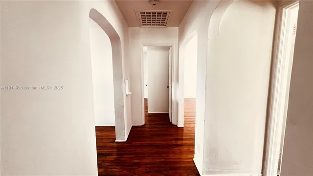 a view of a hallway with wooden floor