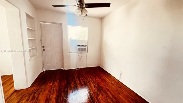 a view of a room with wooden floor and a ceiling fan