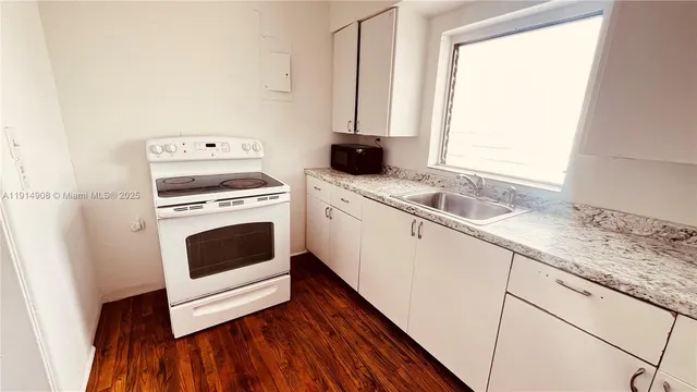 a kitchen with a white stove top oven and sink
