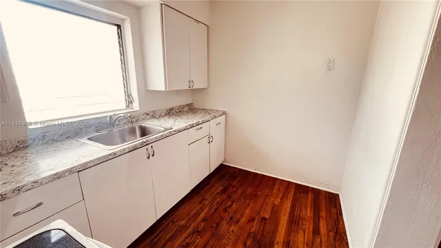 a utility room with wooden floor washer and dryer