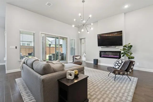 a living room with furniture a flat screen tv and a large window