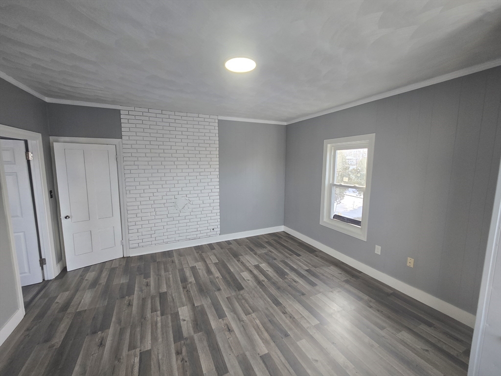 351 Tecumseh Street, Unit 2 Fall River, MA 02721 - Photo 12 of 14 a view of an empty room with wooden floor and a window