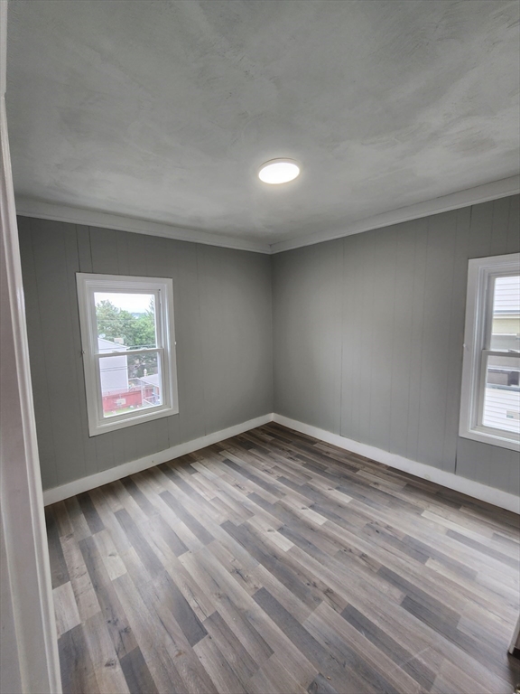 351 Tecumseh Street, Unit 2 Fall River, MA 02721 - Photo 6 of 14 an empty room with wooden floor and windows