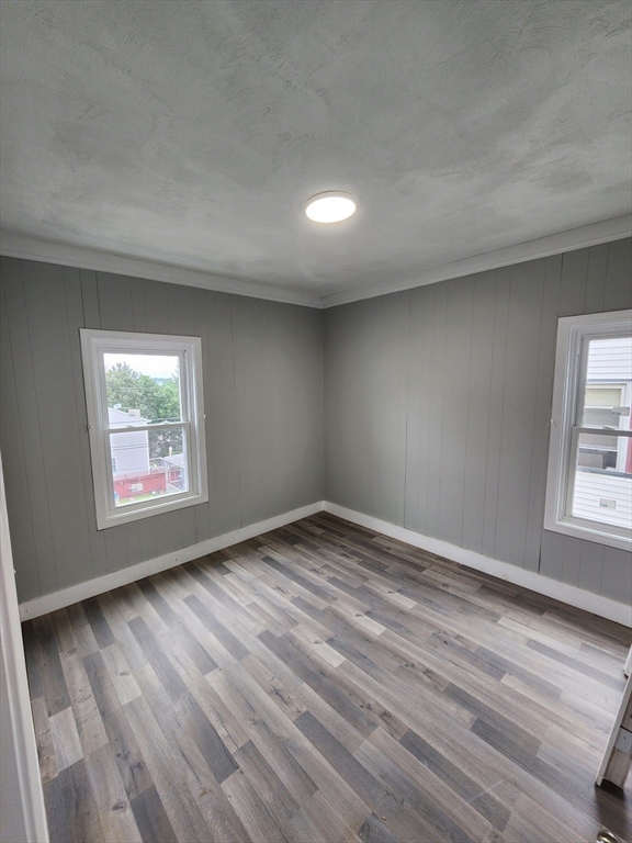 351 Tecumseh Street, Unit 2 Fall River, MA 02721 - Photo 7 of 14 an empty room with wooden floor and windows