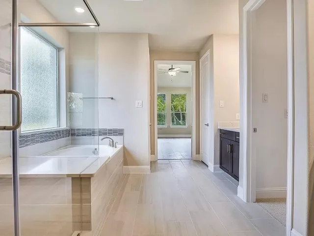 a bathroom with a tub sink and mirror